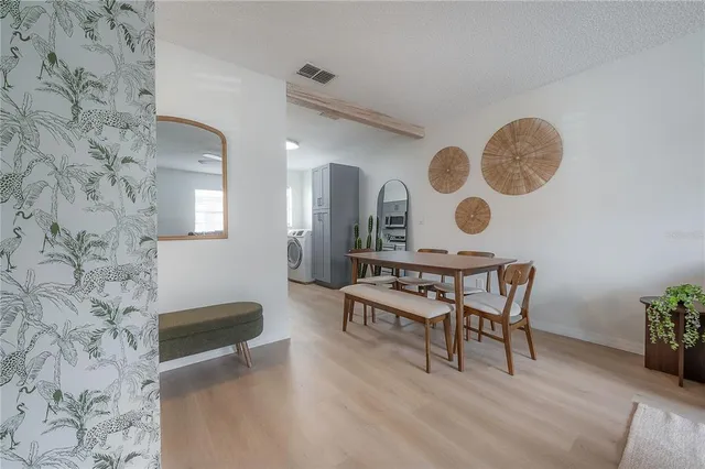 a living room with couches and a fireplace with wooden floor