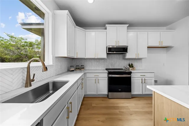 a kitchen with a white cabinets stove and sink
