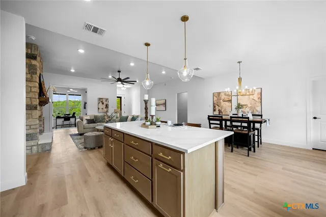 a large kitchen with kitchen island a stove a sink a center island and couches