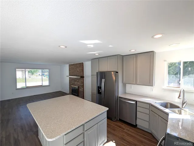 a kitchen with stainless steel appliances a refrigerator sink and wooden cabinets