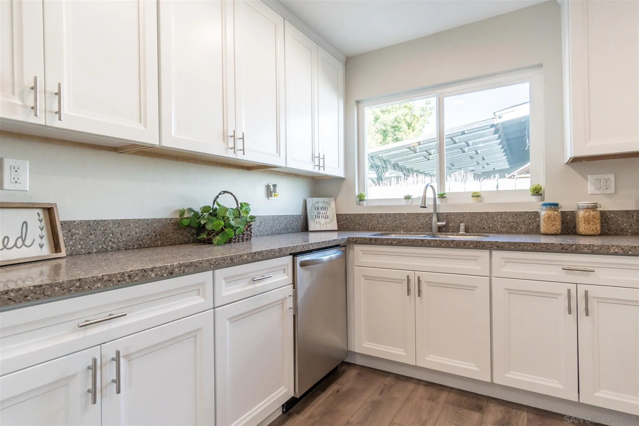 466 Cedar Street El Cajon, CA 92021 - Photo 12 of 26 a kitchen with granite countertop white cabinets and a window