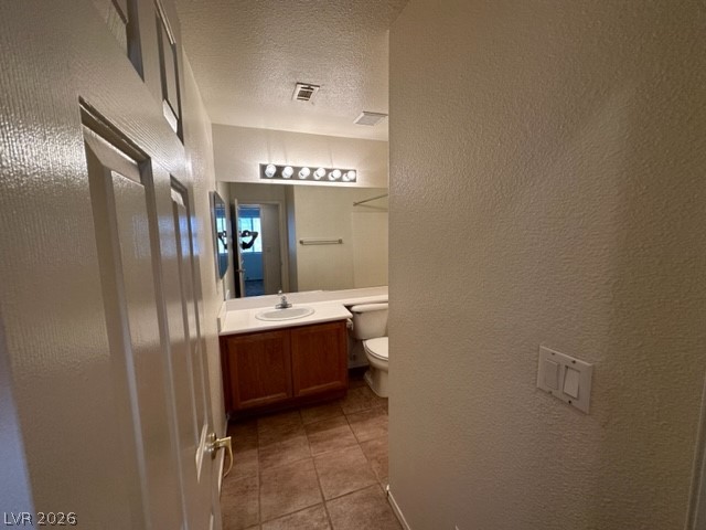 285 Spring Palms Street Henderson, NV 89012 - Photo 18 of 38 Bathroom with vanity, toilet, tile patterned floors, a textured ceiling, and visible vents