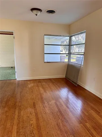 wooden floor in an empty room with a window