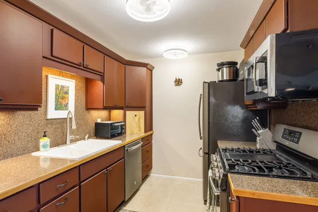 a kitchen with stainless steel appliances granite countertop a refrigerator and a sink