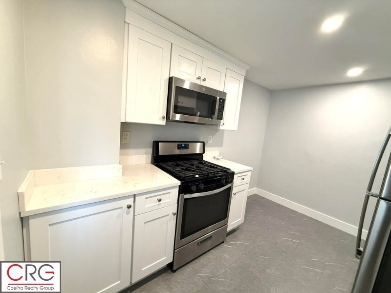 45 North Emerson Street, Unit 1 Wakefield, MA 01880 - Photo 11 of 12 a kitchen with a stove and a microwave