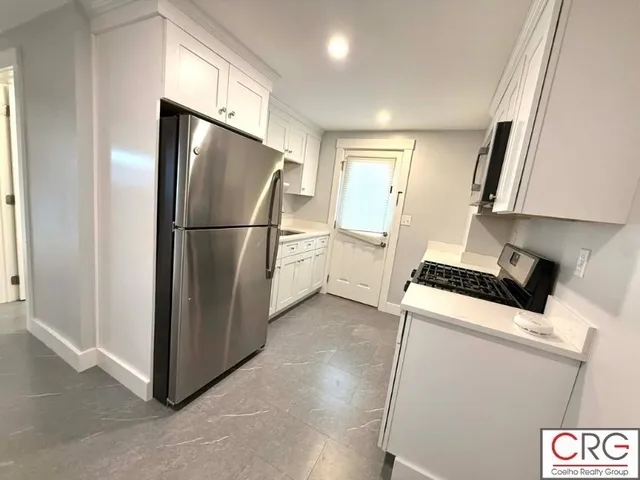 a view of a kitchen with a sink refrigerator and window