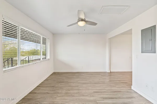 a view of an empty room with wooden floor and a window