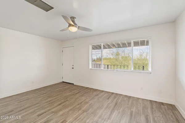 an empty room with wooden floor and windows