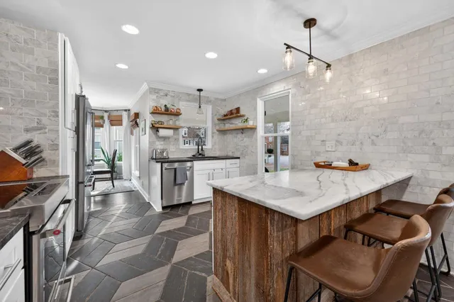 a kitchen that has a lot of cabinets in it and wooden floors