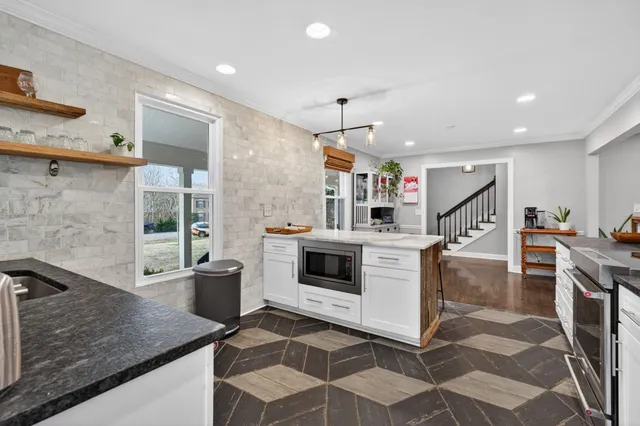a kitchen with stainless steel appliances granite countertop a sink and a stove