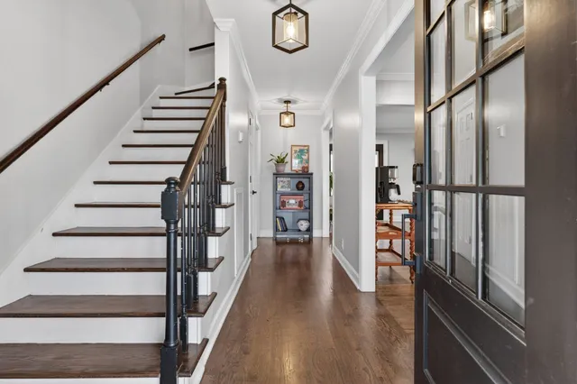a view of a hallway with wooden floor and staircase