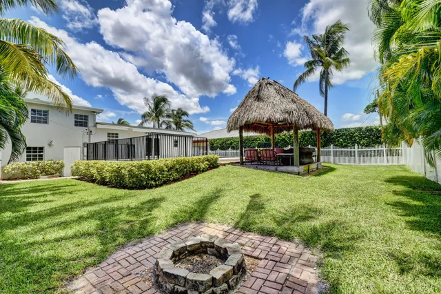 a view of a house with backyard and sitting area