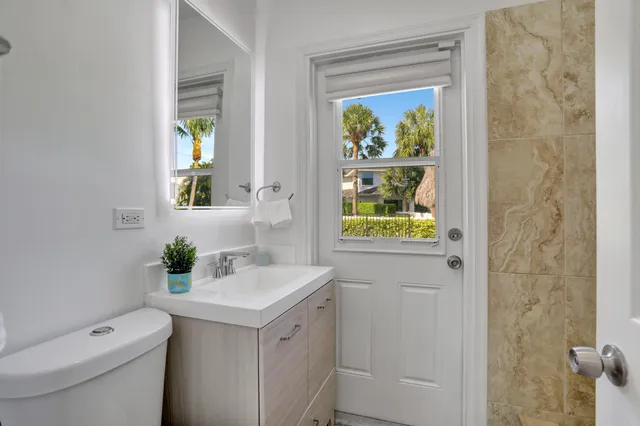 a bathroom with a sink a toilet and painting on the wall