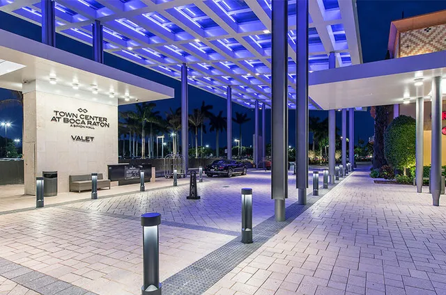 a view of a street with a building and couple of cars parked in front of it