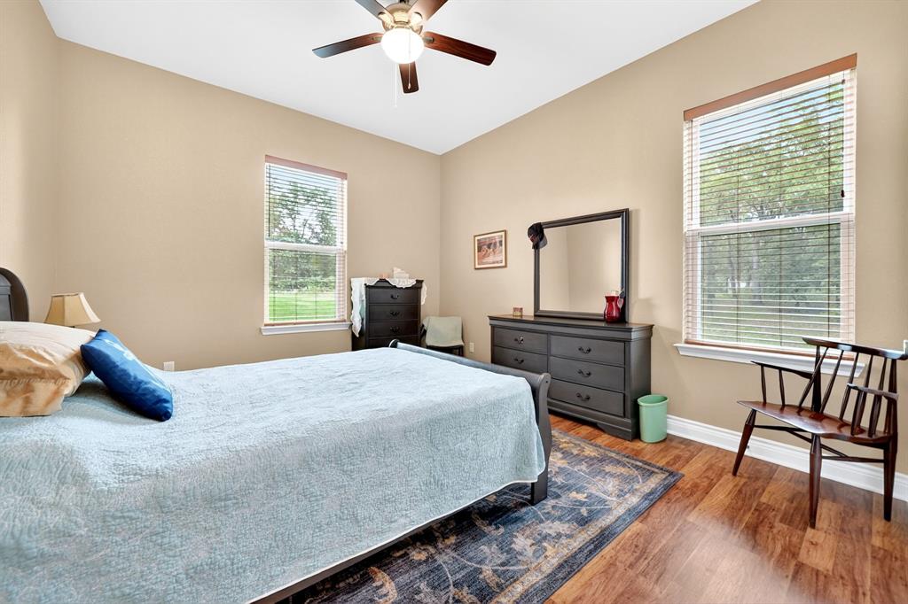 5230 Esquire Estates Road Mabank, TX 75156 - Photo 21 of 39 Spacious room featuring wood-finish flooring, two windows with blinds, a ceiling fan, and crown molding