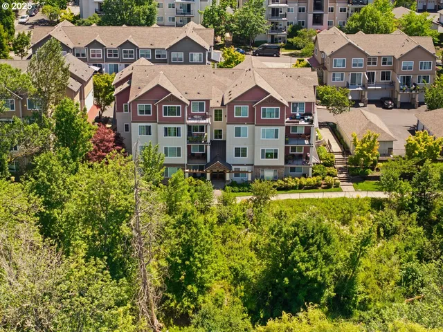 an aerial view of residential houses with yard and car parked
