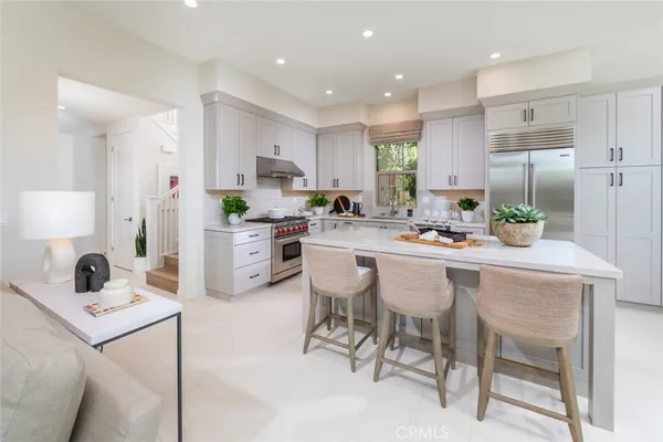 a kitchen with a dining table chairs sink and cabinets