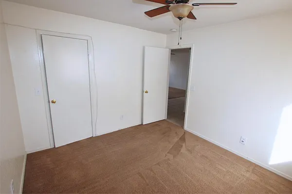 a view of a hallway with a chandelier fan
