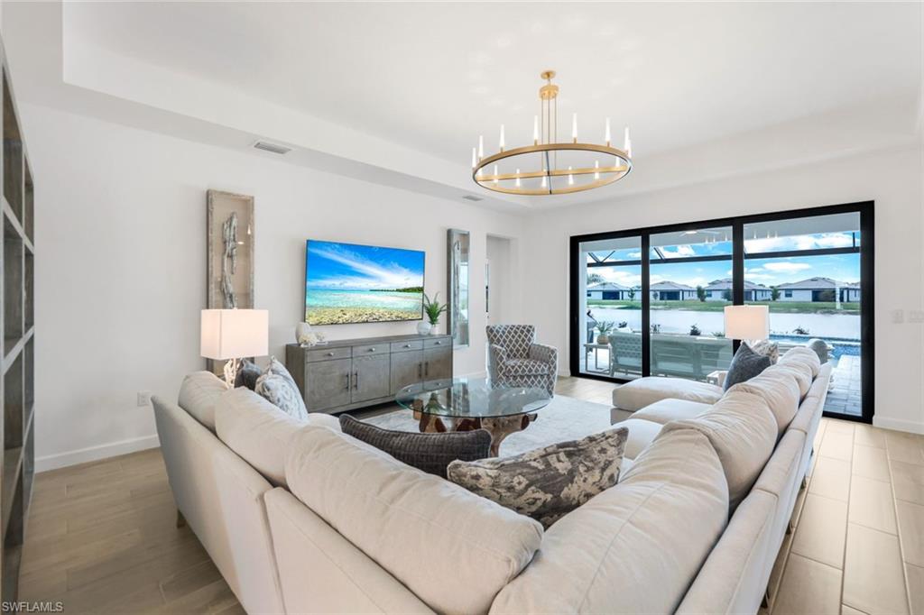 11211 Canopy Loop Fort Myers, FL 33913 - Photo 6 of 49 Living room with a notable chandelier and a tray ceiling