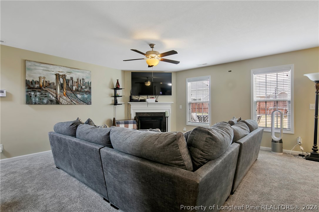 Undisclosed Address Hope Mills, NC 28348 - Photo 11 of 46 a living room with furniture a fireplace and a flat screen tv