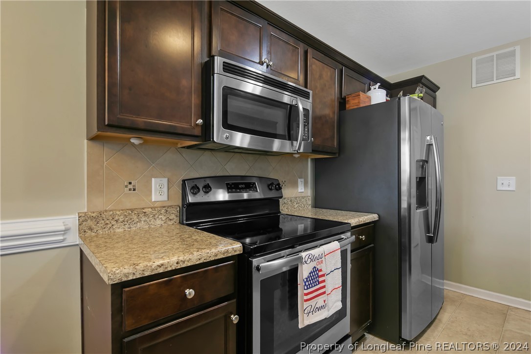 Undisclosed Address Hope Mills, NC 28348 - Photo 17 of 46 a kitchen with stainless steel appliances granite countertop a stove and a microwave