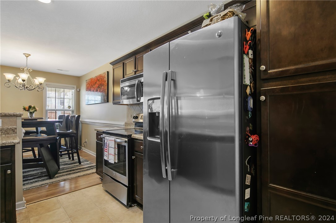 Undisclosed Address Hope Mills, NC 28348 - Photo 18 of 46 a kitchen with a refrigerator and chairs
