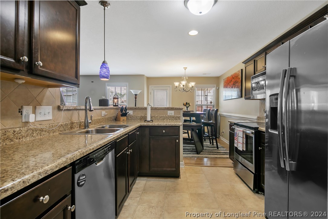 Undisclosed Address Hope Mills, NC 28348 - Photo 19 of 46 a kitchen with stainless steel appliances granite countertop a sink a stove and a refrigerator
