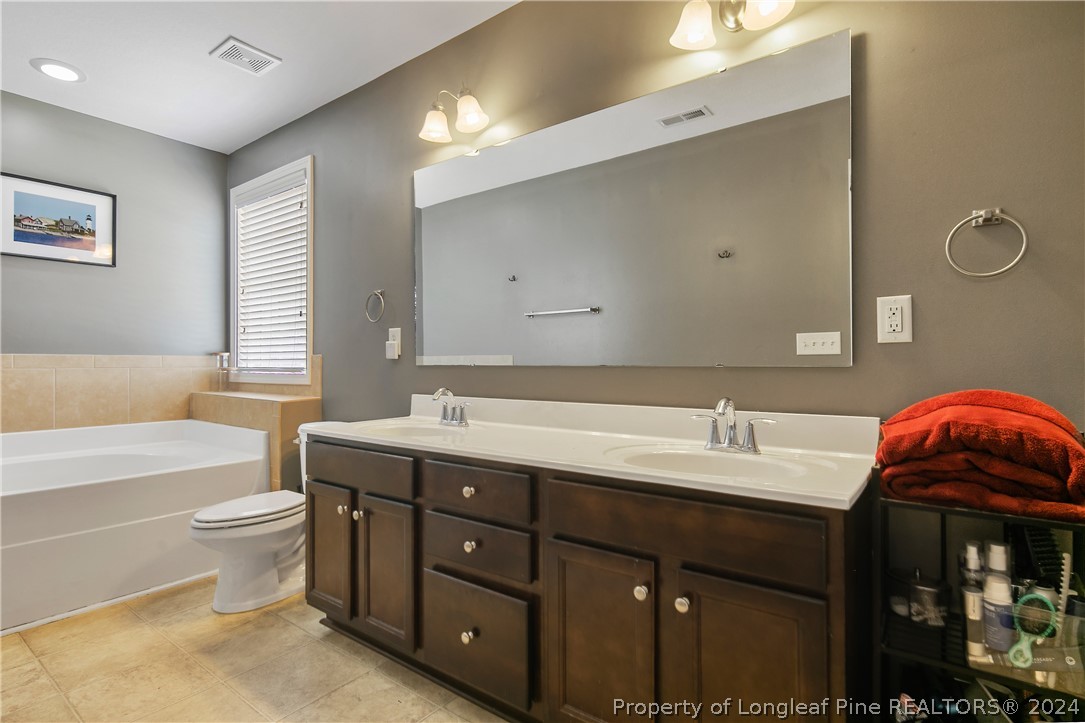 Undisclosed Address Hope Mills, NC 28348 - Photo 30 of 46 a bathroom with a double vanity sink mirror and toilet