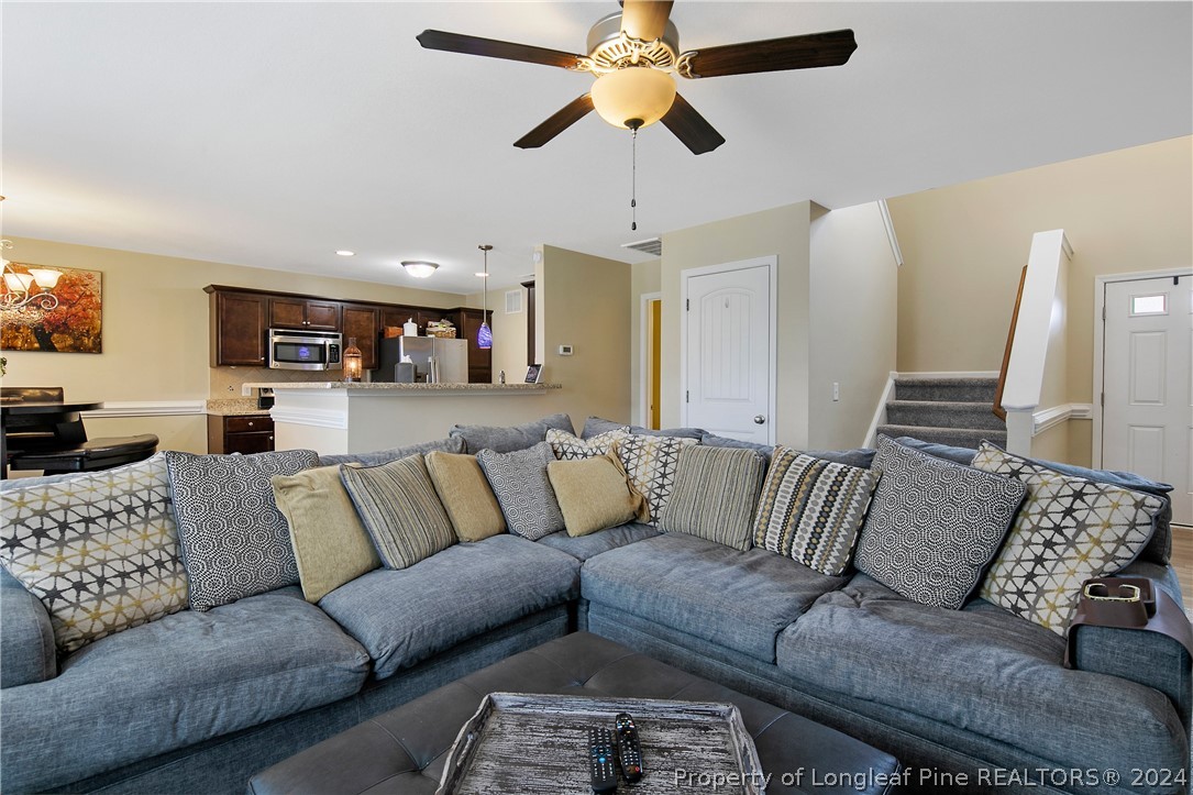 Undisclosed Address Hope Mills, NC 28348 - Photo 8 of 46 a view of living room kitchen with furniture and a ceiling fan