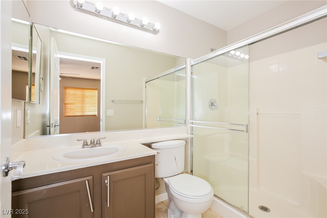 7202 Cestrum Road Las Vegas, NV 89113 - Photo 11 of 15 Bathroom with toilet, a stall shower, and vanity