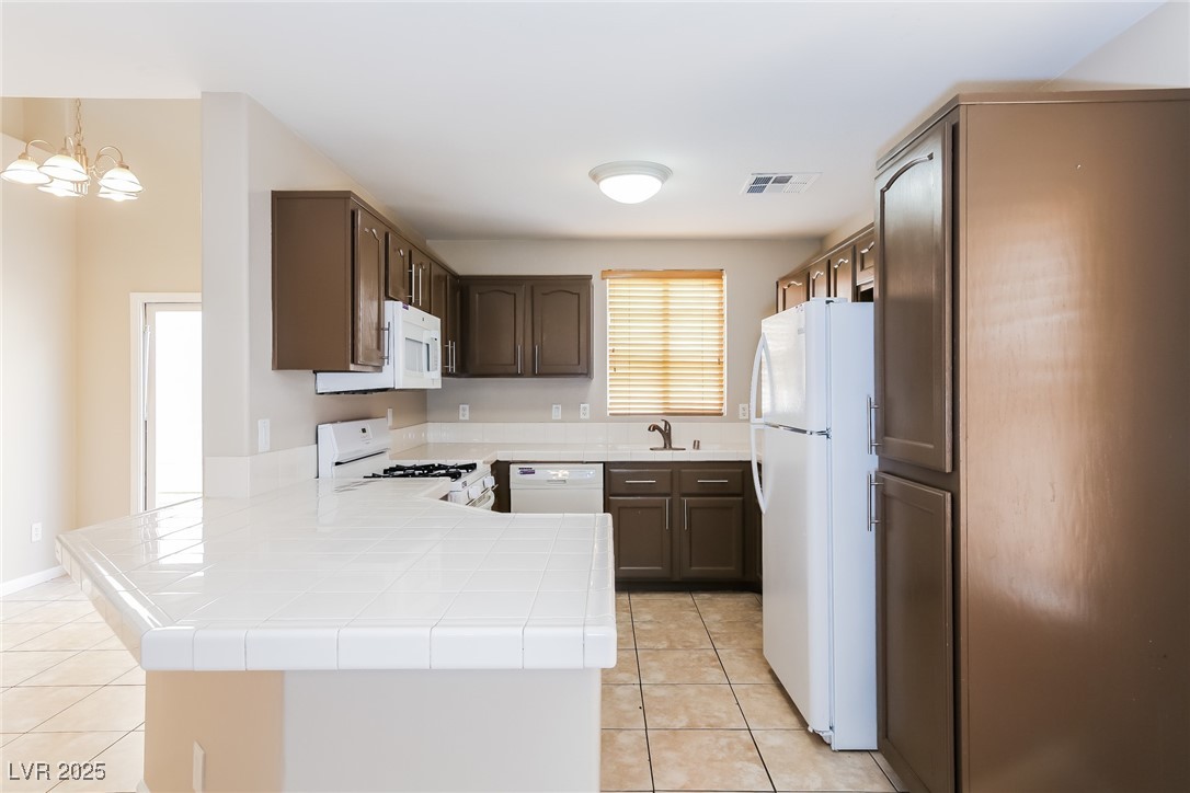 7202 Cestrum Road Las Vegas, NV 89113 - Photo 5 of 15 Kitchen featuring white appliances, a peninsula, v