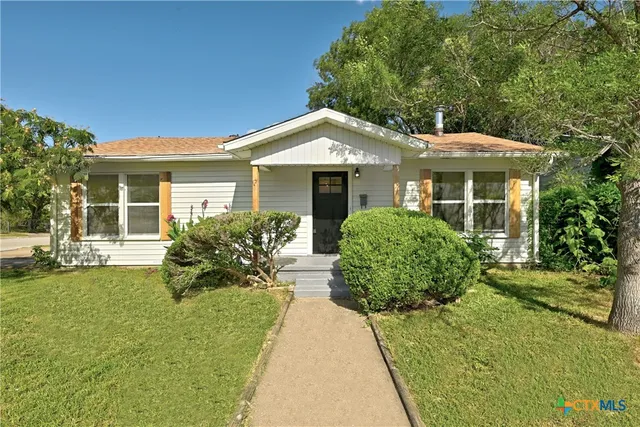a front view of a house with a garden