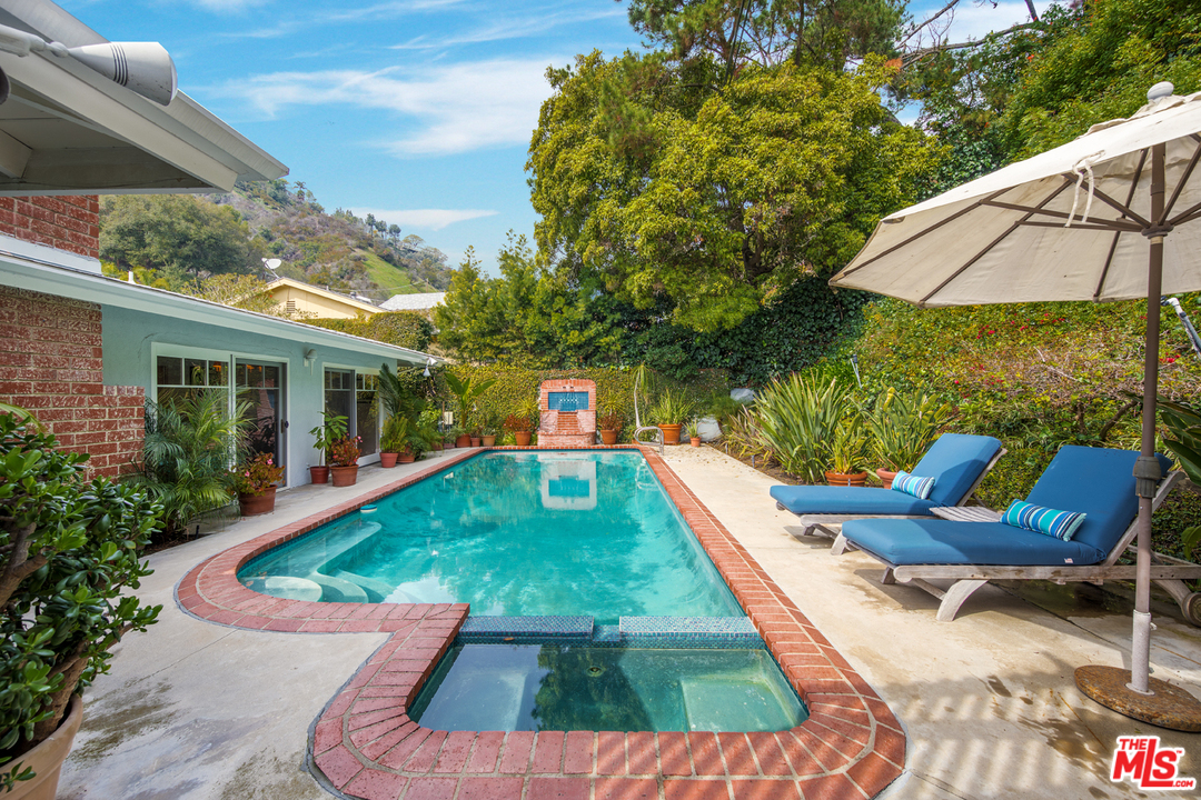 1826 Roscomare Road Los Angeles, CA 90077 - Photo 10 of 12 a view of a swimming pool with a lounge chairs