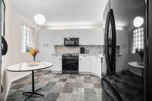 a kitchen with a stove a refrigerator and cabinets