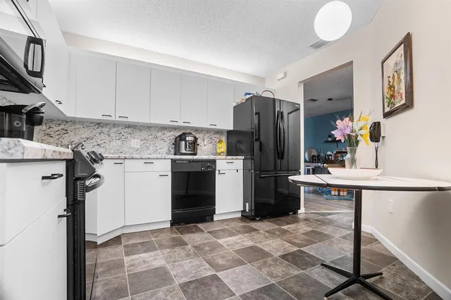 a kitchen with stainless steel appliances granite countertop a stove microwave and sink
