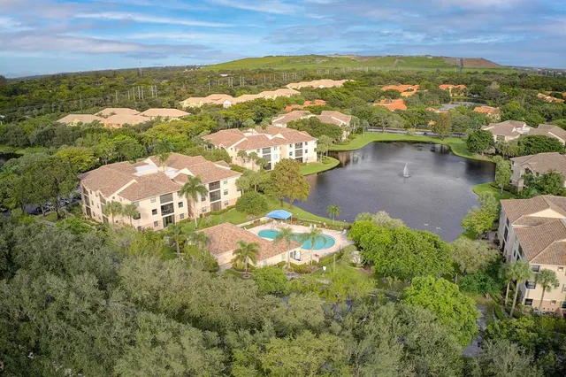 an aerial view of a house with a garden and lake view