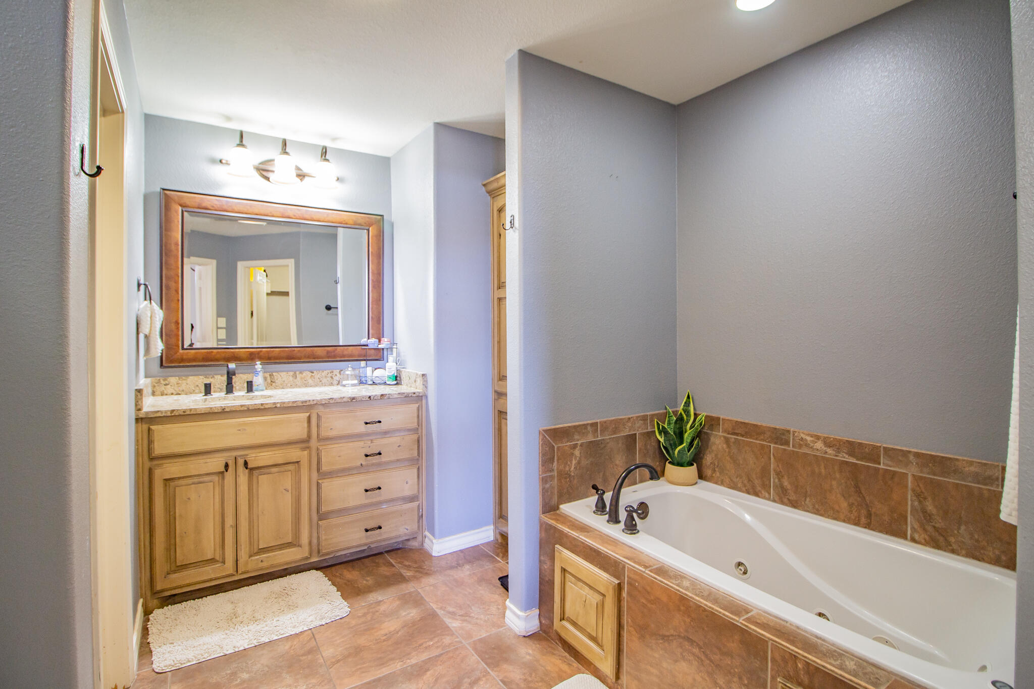 3013 110th Street Lubbock, TX 79423 - Photo 19 of 22 a bathroom with a tub sink and mirror