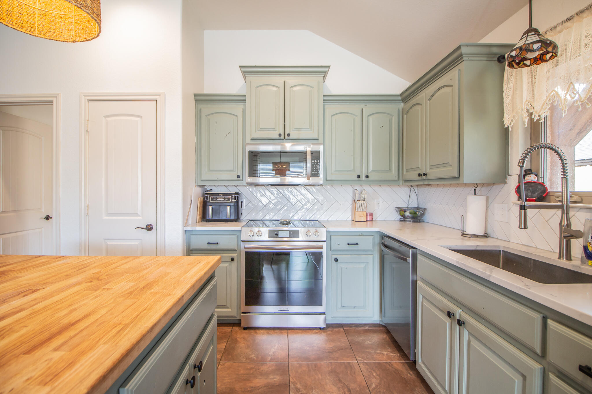 3013 110th Street Lubbock, TX 79423 - Photo 7 of 22 a kitchen with a stove sink and cabinets