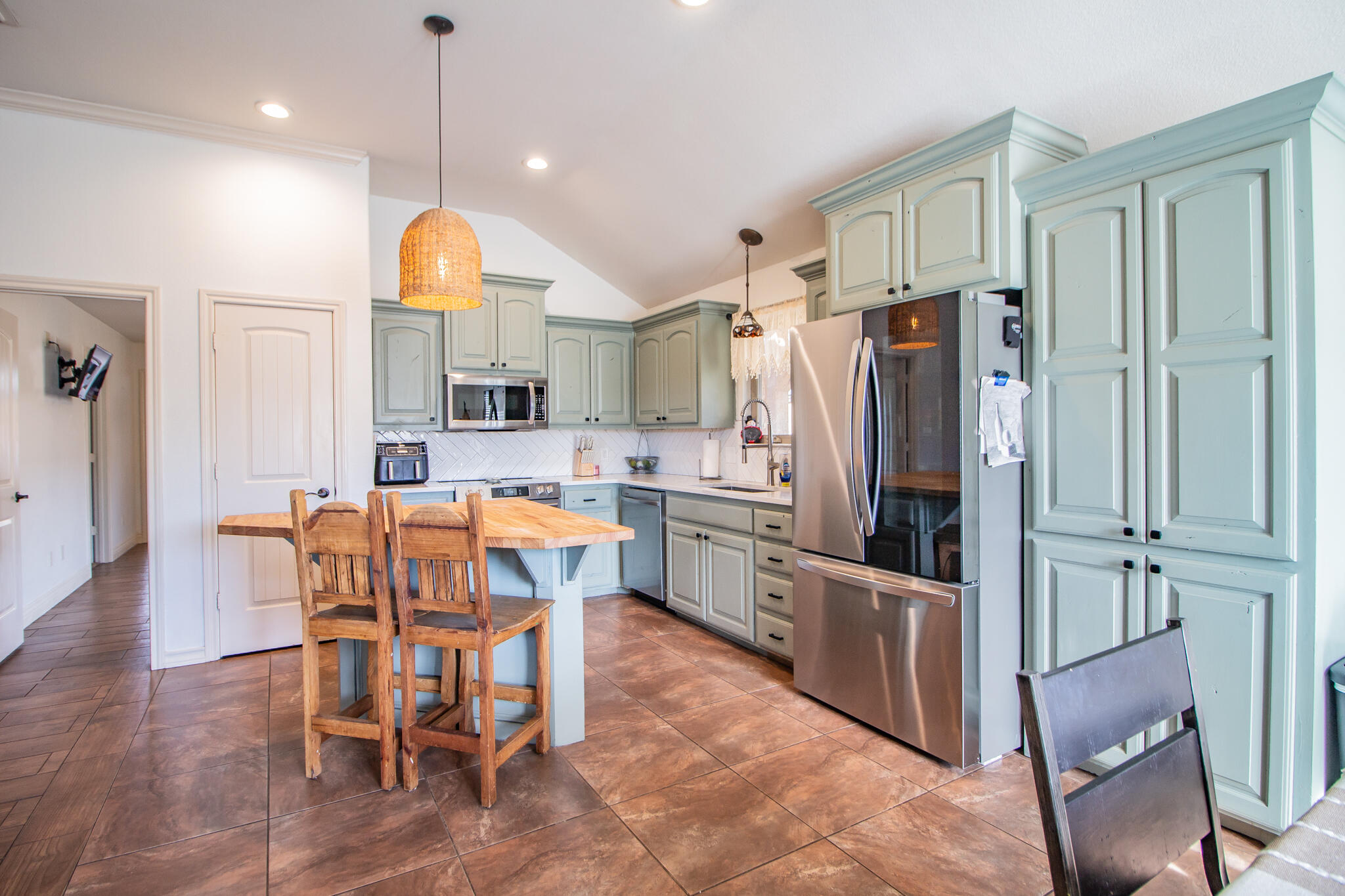 3013 110th Street Lubbock, TX 79423 - Photo 9 of 22 a kitchen with stainless steel appliances granite countertop a refrigerator a oven a sink a dining table and chairs with wooden floor