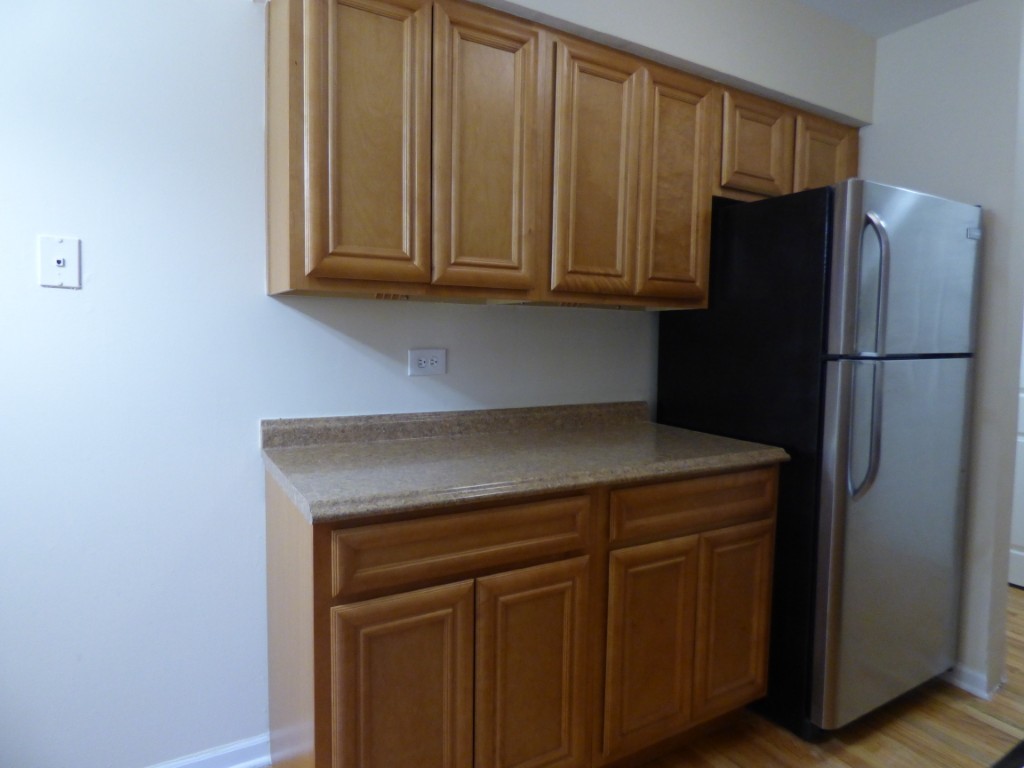 1626 West Estes Avenue, Unit 1F Chicago, IL 60626 - Photo 3 of 9 a kitchen with a refrigerator and cabinets