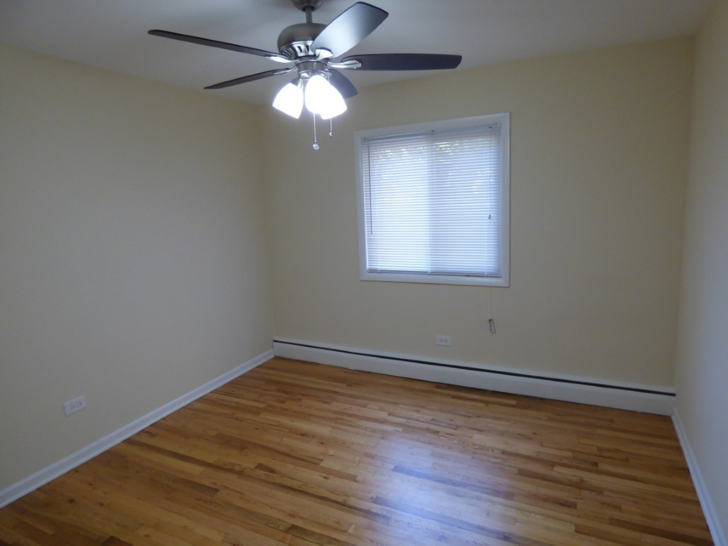 1626 West Estes Avenue, Unit 1F Chicago, IL 60626 - Photo 8 of 9 a view of an empty room with wooden floor and a window