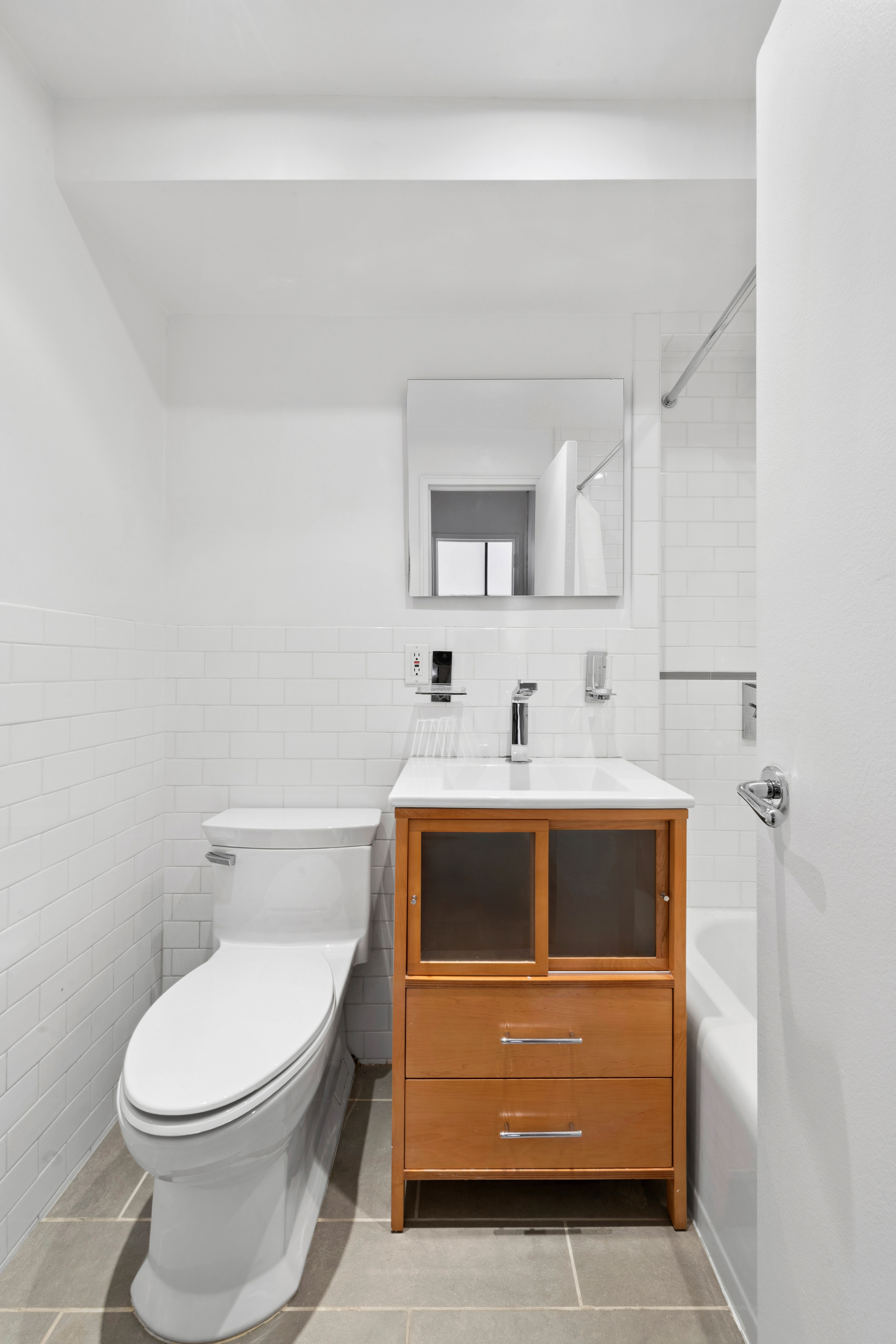 69 West 9th Street, Unit 8H Manhattan, NY 10011 - Photo 4 of 7 a bathroom with a sink a toilet and mirror