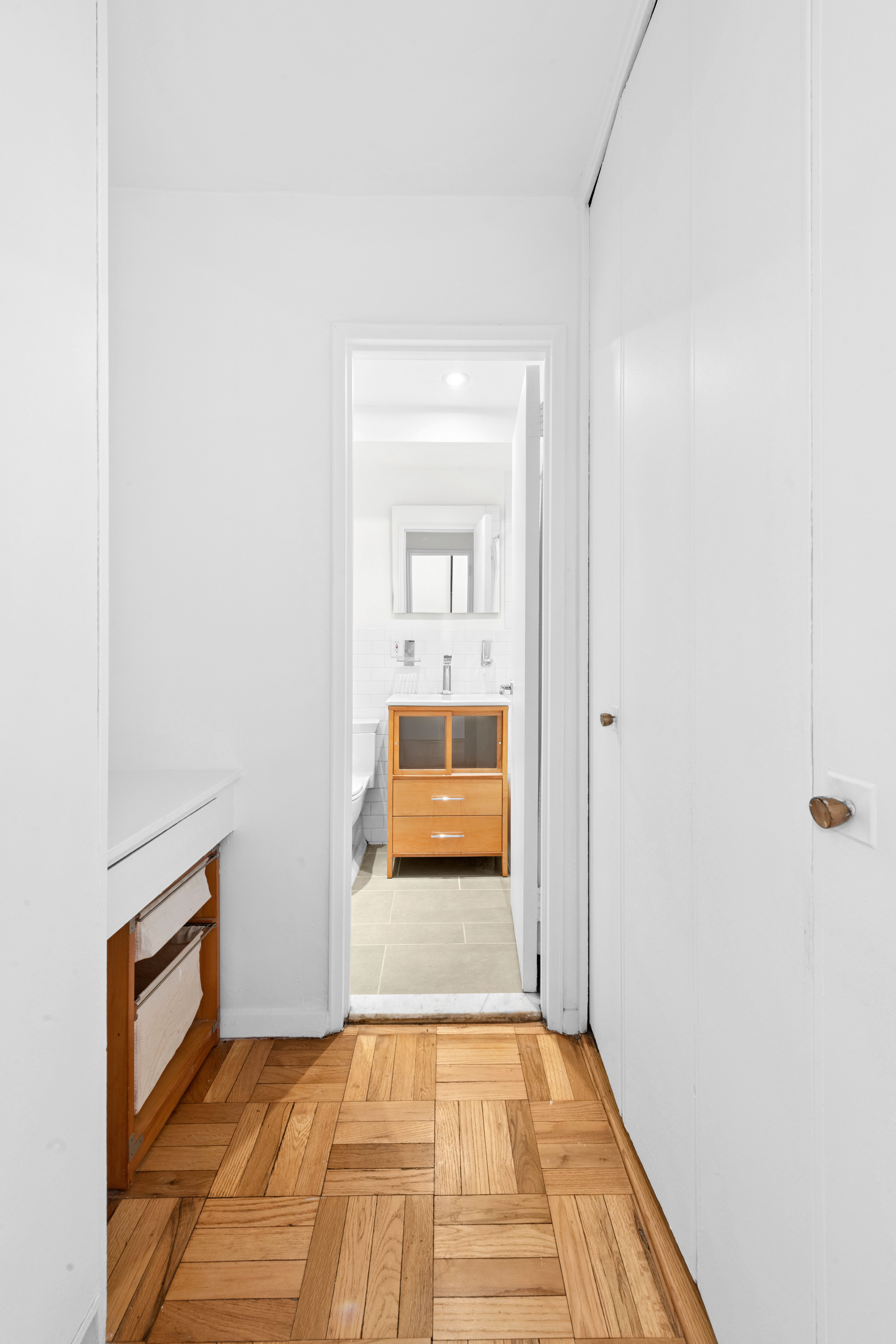 69 West 9th Street, Unit 8H Manhattan, NY 10011 - Photo 5 of 7 a view of a hallway with wooden floor and a living room