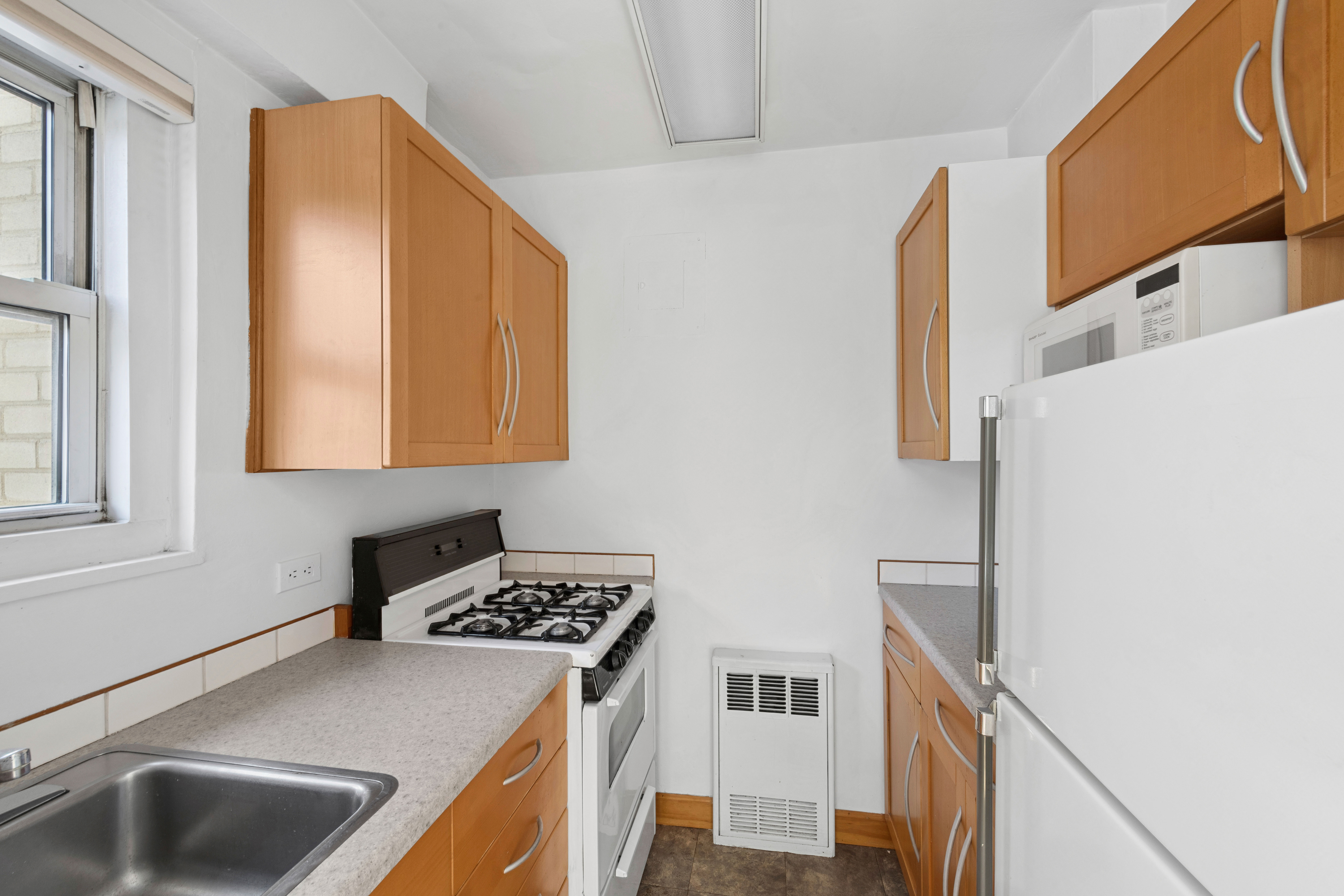 69 West 9th Street, Unit 8H Manhattan, NY 10011 - Photo 6 of 7 a kitchen with a sink and a refrigerator