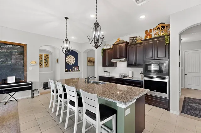 a open kitchen with stainless steel appliances granite countertop a stove and a refrigerator
