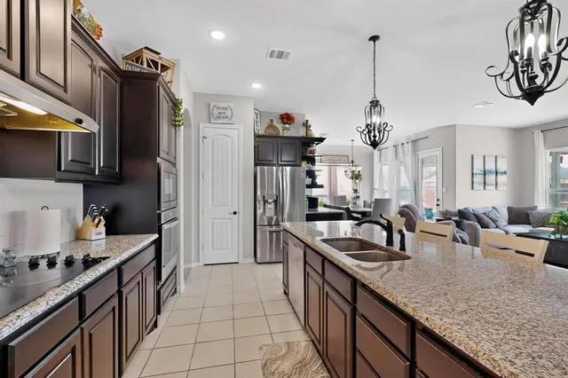 a kitchen with granite countertop a sink a counter top space appliances and cabinets