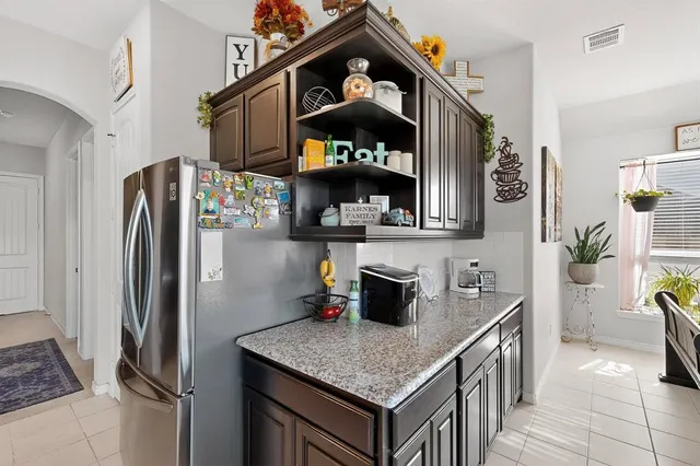 a kitchen with stainless steel appliances granite countertop a refrigerator a stove and a sink