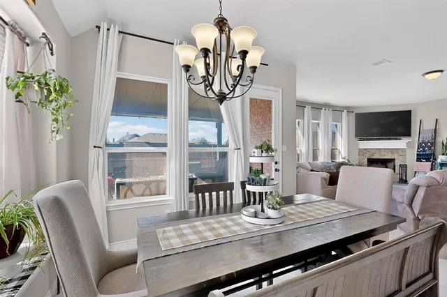 a view of a dining room with furniture a chandelier and wooden floor