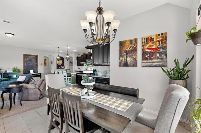 a view of a dining room with furniture a chandelier and wooden floor