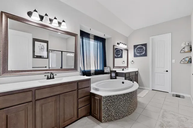 a spacious bathroom with a tub a sink and mirror
